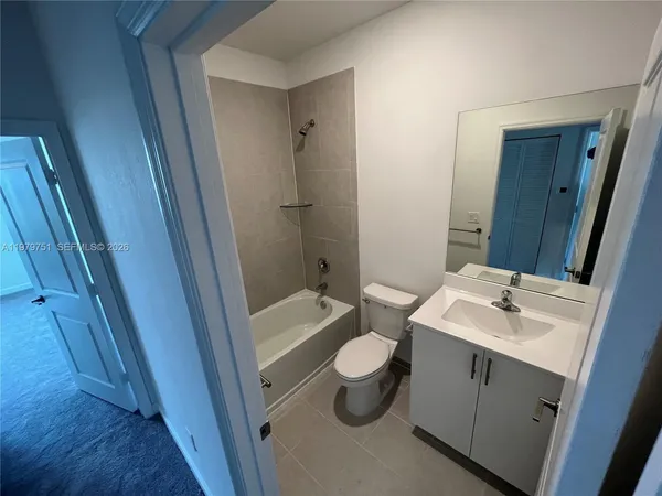 an empty room with a window and a ceiling fan