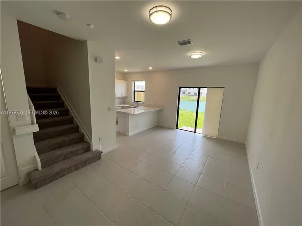 a large white kitchen with stainless steel appliances granite countertop a stove a refrigerator a sink and a refrigerator