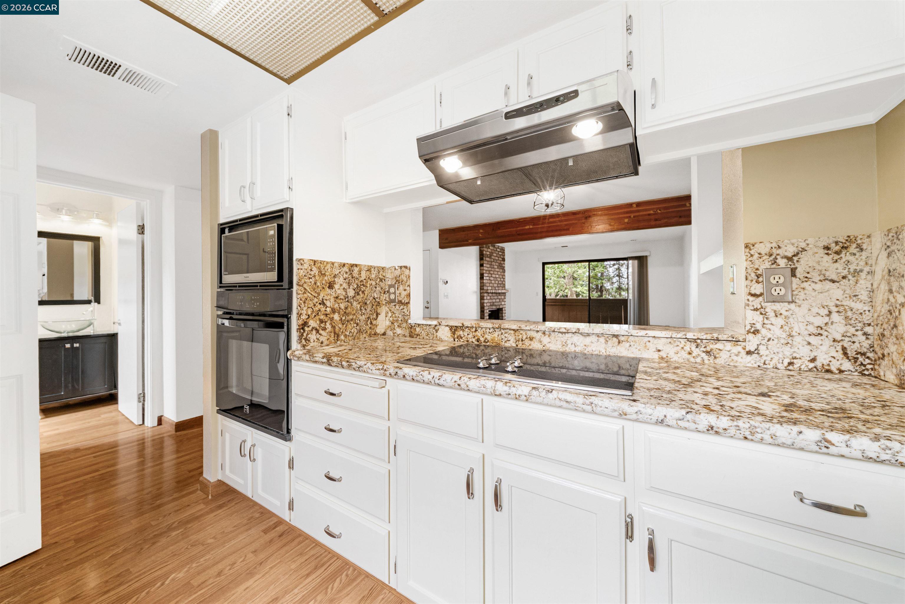 2055 Sierra Road, Unit 106 Concord, CA 94518 - Photo 16 of 37 a kitchen with granite countertop cabinets stainless steel appliances and a wooden floor