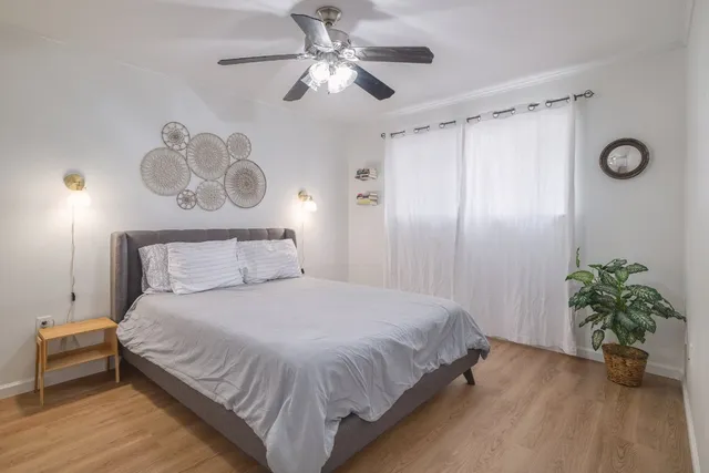 a bedroom with a bed chandelier and a window