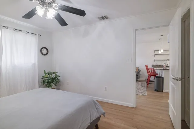 a bedroom with a bed and a chandelier fan