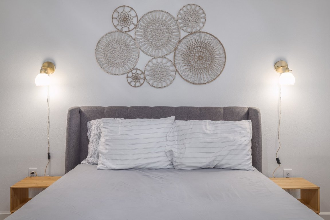 1422 Collier Street, Unit 105 Austin, TX 78704 - Photo 14 of 27 a bedroom with a bed and a chandelier