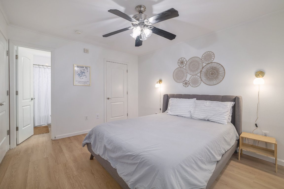 1422 Collier Street, Unit 105 Austin, TX 78704 - Photo 15 of 27 a bedroom with a bed and a chandelier