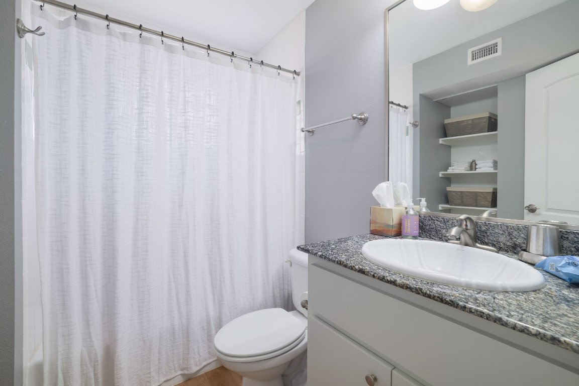 1422 Collier Street, Unit 105 Austin, TX 78704 - Photo 16 of 27 a bathroom with a granite countertop sink and a mirror