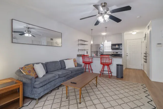 a living room with furniture and kitchen view