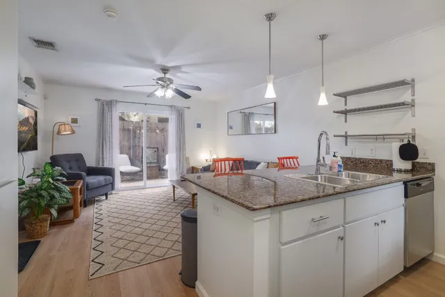 a kitchen with sink stove and living room view