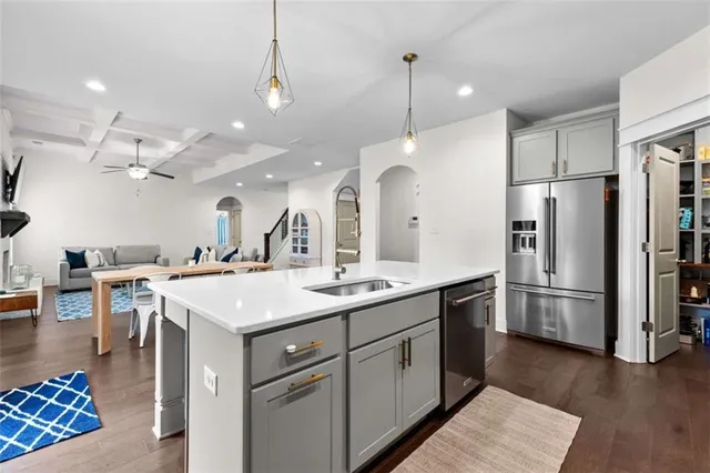 a kitchen with a sink a counter space appliances and cabinets