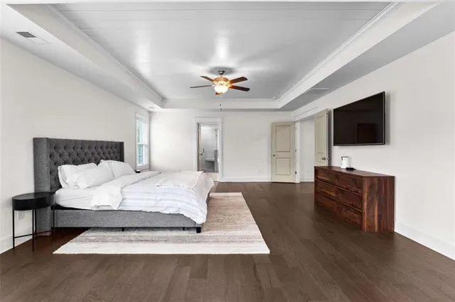 a spacious bedroom with a bed and a flat screen tv