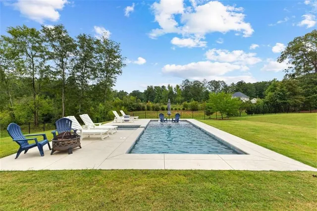 a view of backyard with swimming pool and outdoor seating