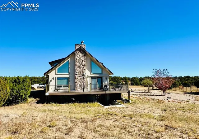 a view of a house with a wooden deck and a mountain