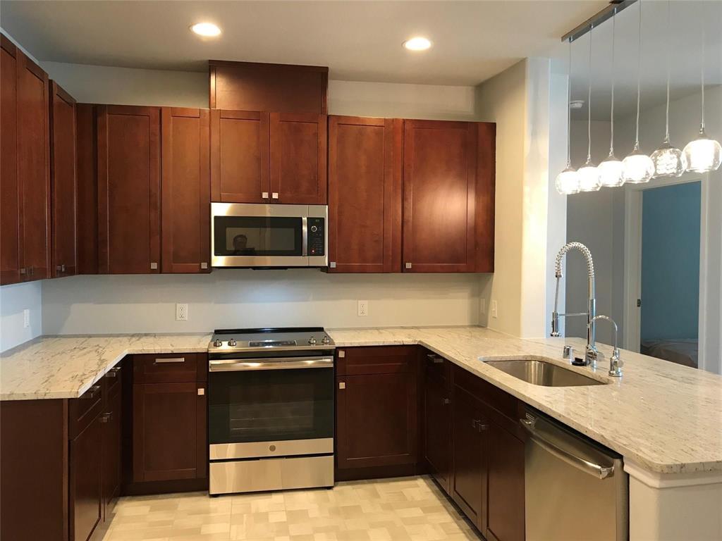 1220 West Trinity Mills Road, Unit 3012 Carrollton, TX 75006 - Photo 1 of 1 Kitchen with appliances with stainless steel finishes, a sink, a peninsula, light stone counters, and recessed lighting