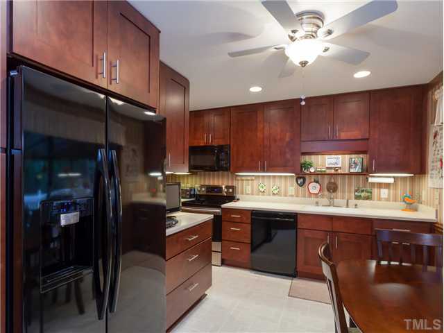 12601 Kristy Circle Raleigh, NC 27613 - Photo 4 of 25 a kitchen with stainless steel appliances granite countertop wooden cabinets a stove top oven a sink and dishwasher