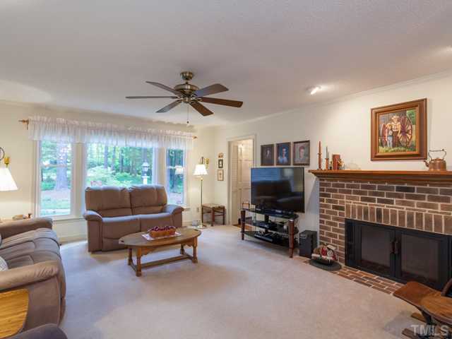 12601 Kristy Circle Raleigh, NC 27613 - Photo 8 of 25 a living room with furniture a fireplace and a flat screen tv