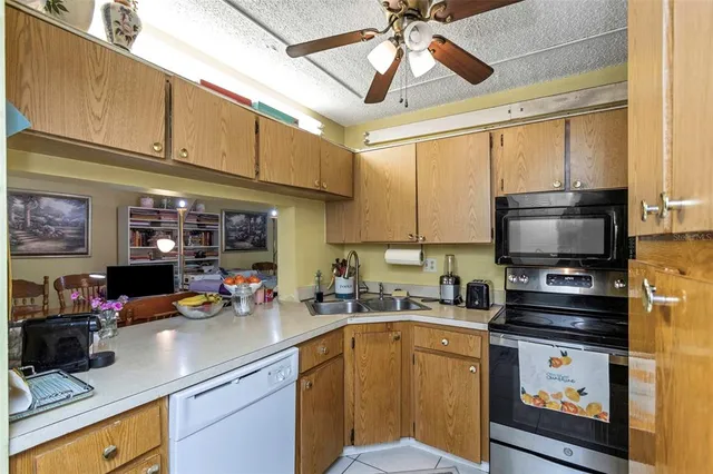 a kitchen with stainless steel appliances a stove a sink a microwave and cabinets