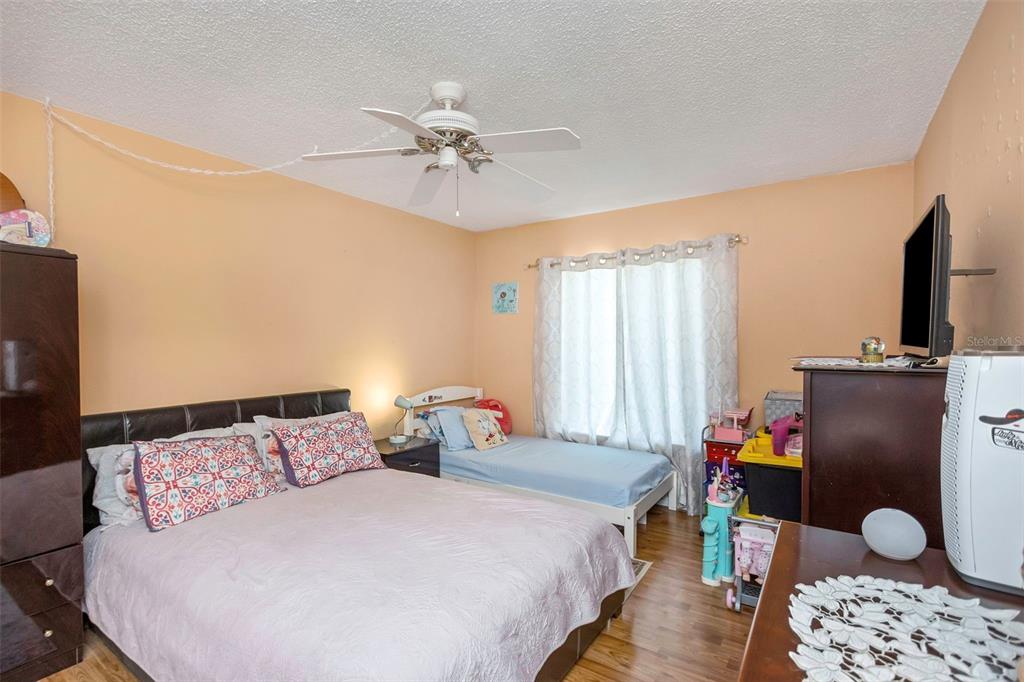 1344 Pine Ridge Circle East, Unit D2 Tarpon Springs, FL 34688 - Photo 17 of 44 a bedroom with a bed and wooden floor