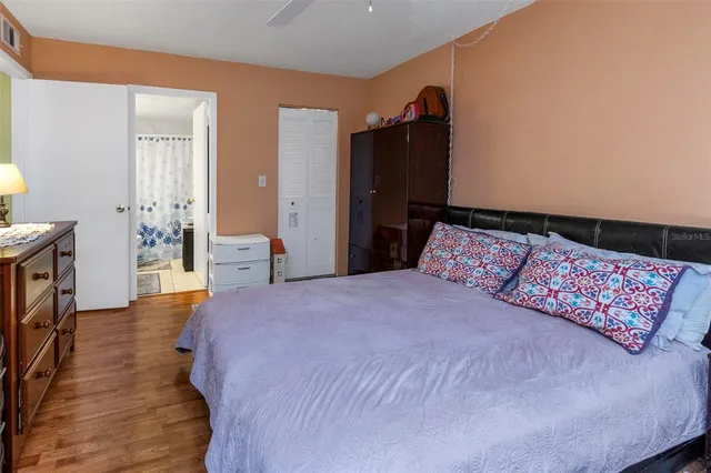 a bedroom with a bed and wooden floor