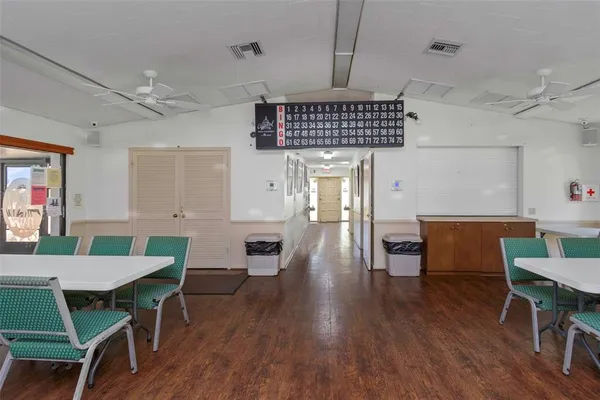 a open kitchen with stainless steel appliances granite countertop a dining table chairs and a refrigerator