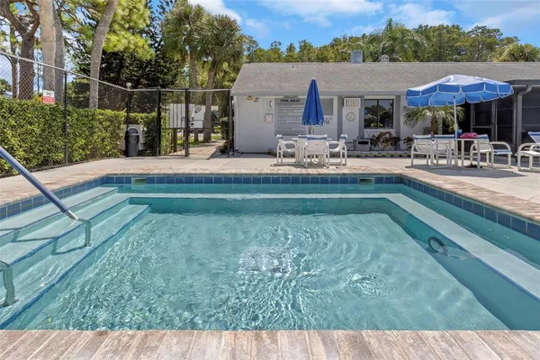 a swimming pool view with a seating space