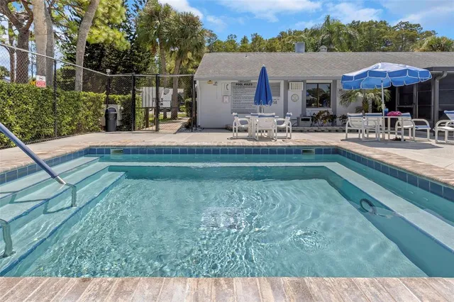 a swimming pool view with a seating space