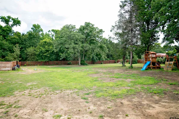 a front view of a house with a garden and trees