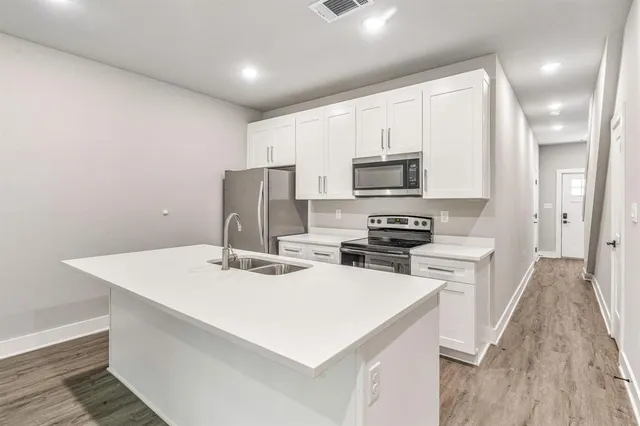a kitchen with a stove a sink and a refrigerator