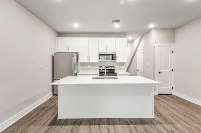 a view of kitchen with cabinets and wooden floor