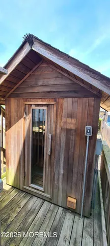 a view of a balcony with wooden chairs and lake view