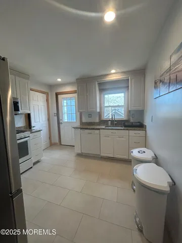 a kitchen with stainless steel appliances a refrigerator sink and microwave