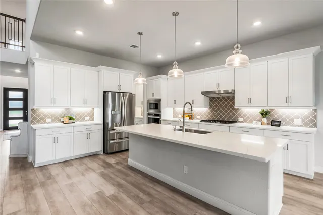 a kitchen with kitchen island a sink stainless steel appliances and cabinets