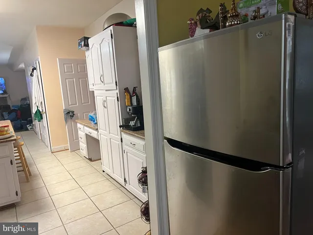 a kitchen with a refrigerator a stove top oven and cabinets