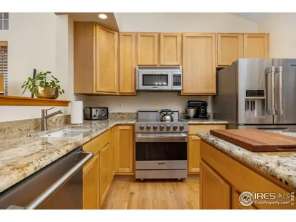 a kitchen with stainless steel appliances granite countertop a sink a stove and a refrigerator