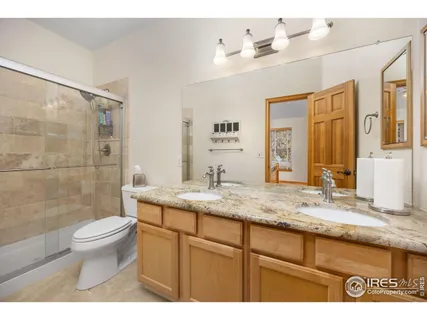 a bathroom with a granite countertop sink a toilet and a mirror