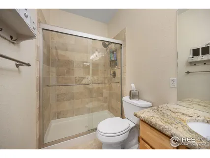 a bathroom with a granite countertop sink a toilet and shower