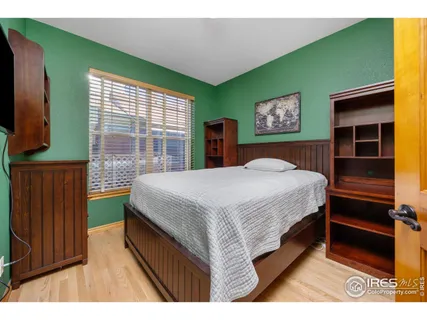 a bedroom with a bed and a flat tv screen on dresser