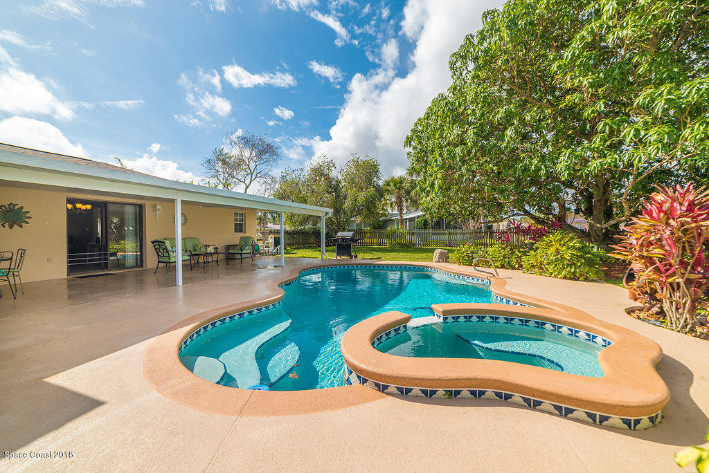 700 Montclair Road Northeast Palm Bay, FL 32905 - Photo 18 of 46 a swimming pool with outdoor seating and yard