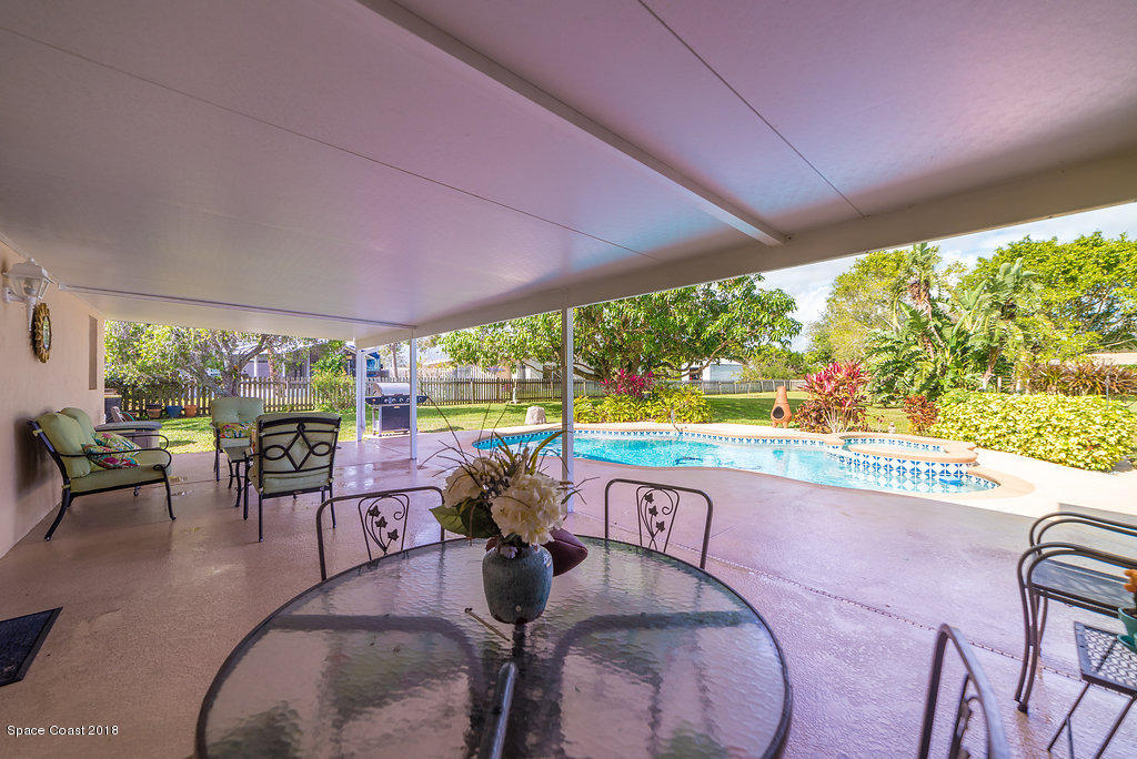 700 Montclair Road Northeast Palm Bay, FL 32905 - Photo 19 of 46 a living room with patio furniture and a garden