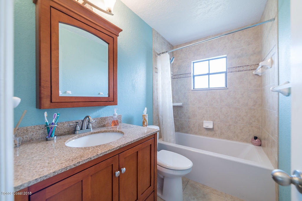 700 Montclair Road Northeast Palm Bay, FL 32905 - Photo 22 of 46 a bathroom with a granite countertop sink toilet and shower