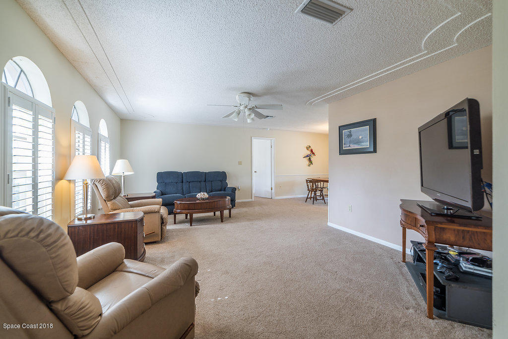 700 Montclair Road Northeast Palm Bay, FL 32905 - Photo 24 of 46 a living room with furniture and a flat screen tv