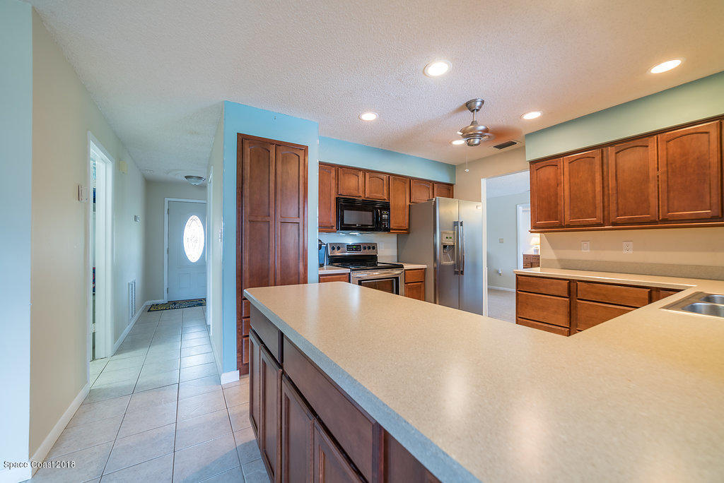 700 Montclair Road Northeast Palm Bay, FL 32905 - Photo 32 of 46 a large kitchen with stainless steel appliances lots of counter space and wooden floor