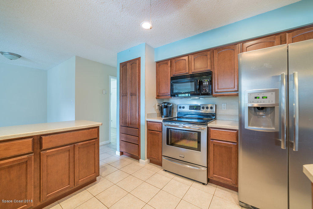 700 Montclair Road Northeast Palm Bay, FL 32905 - Photo 34 of 46 a kitchen with stainless steel appliances granite countertop a refrigerator and a stove top oven