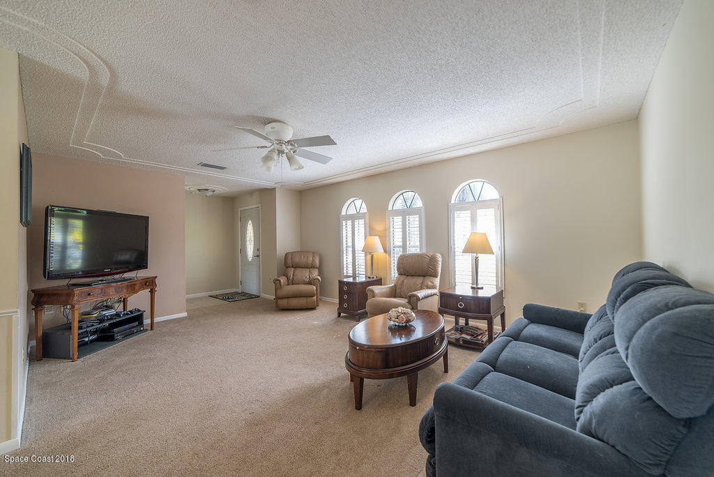 700 Montclair Road Northeast Palm Bay, FL 32905 - Photo 36 of 46 a living room with furniture a flat screen tv and a large window