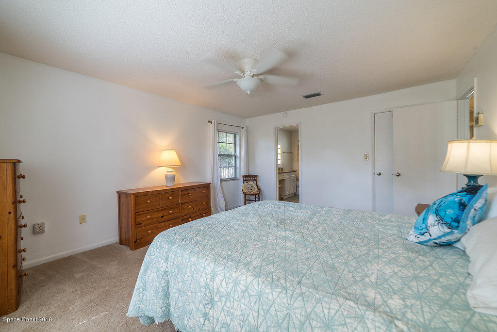 700 Montclair Road Northeast Palm Bay, FL 32905 - Photo 41 of 46 a bedroom with a bed and a chandelier
