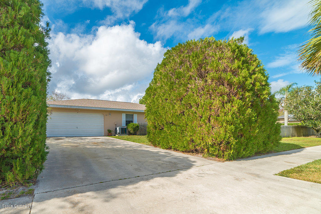 700 Montclair Road Northeast Palm Bay, FL 32905 - Photo 6 of 46 a front view of a house with a yard and garage