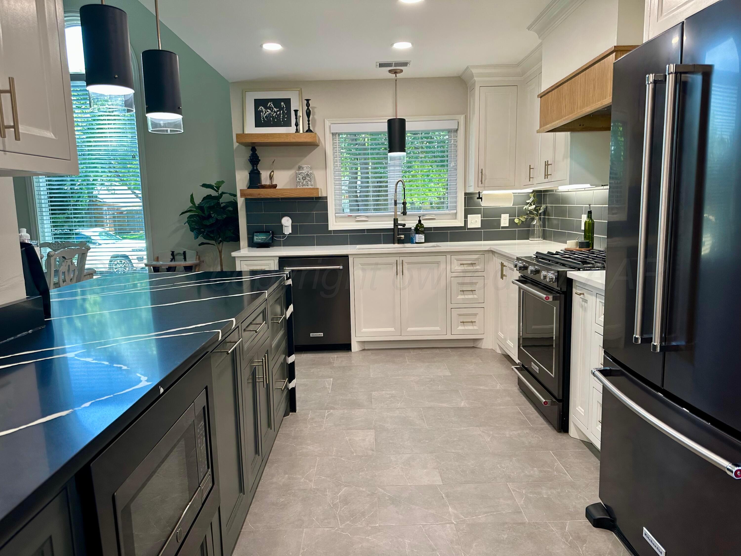 7714 Baughman Drive Amarillo, TX 79121 - Photo 11 of 37 a kitchen with stainless steel appliances granite countertop a sink stove and refrigerator