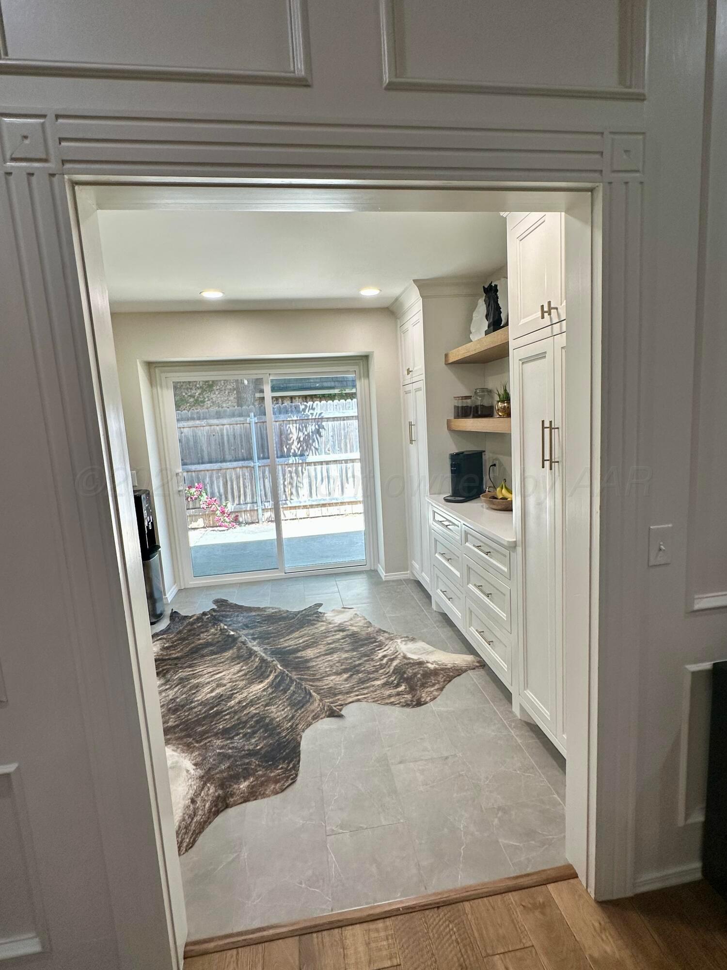 7714 Baughman Drive Amarillo, TX 79121 - Photo 16 of 37 a view of a hallway to a livingroom with wooden floor and windows