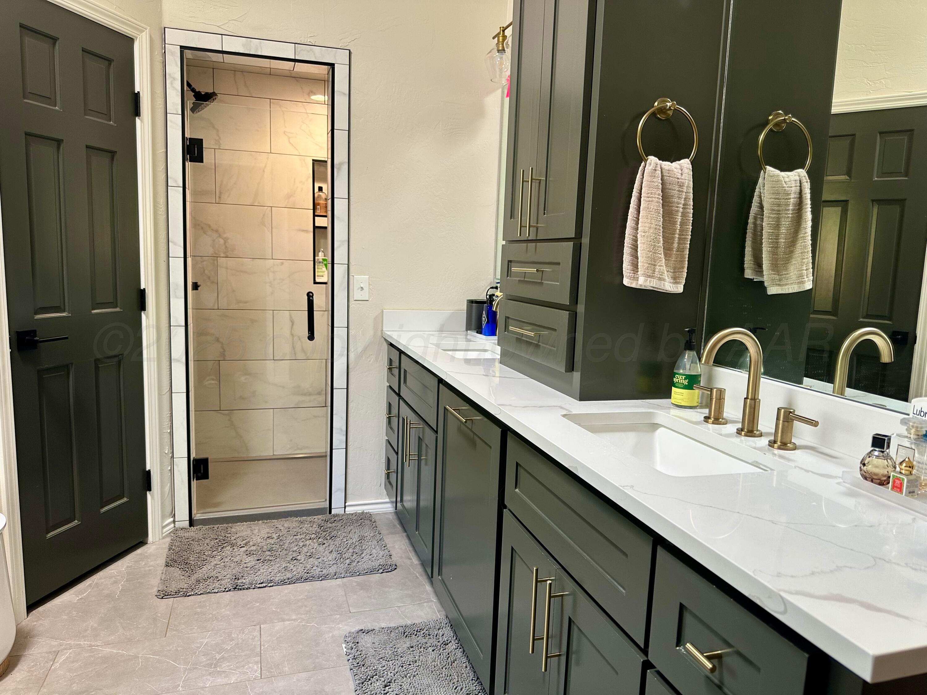 7714 Baughman Drive Amarillo, TX 79121 - Photo 21 of 37 a bathroom with a double vanity sink a mirror and shower
