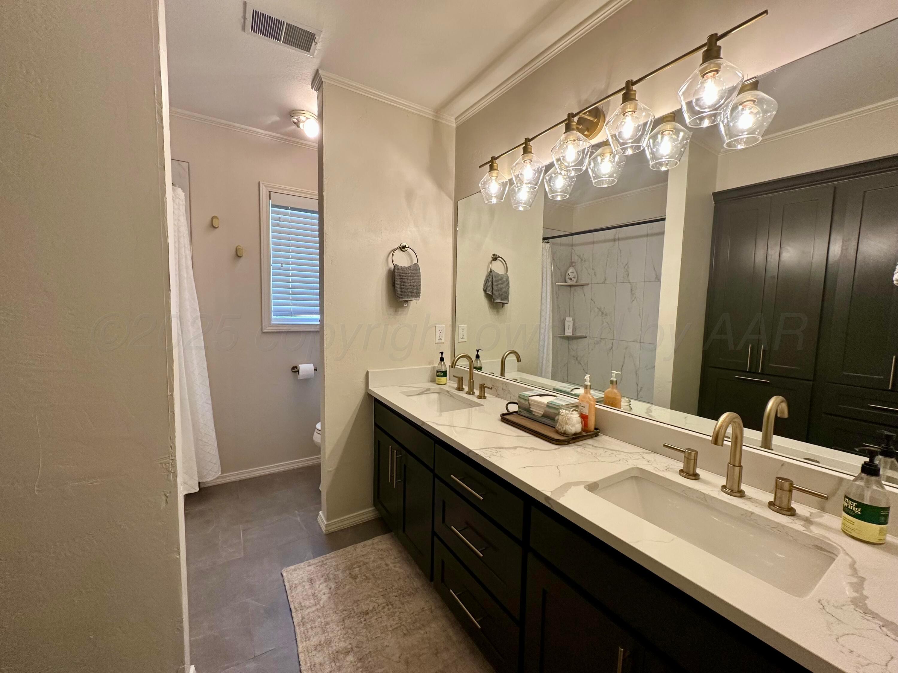7714 Baughman Drive Amarillo, TX 79121 - Photo 26 of 37 a bathroom with a sink double vanity and a mirror