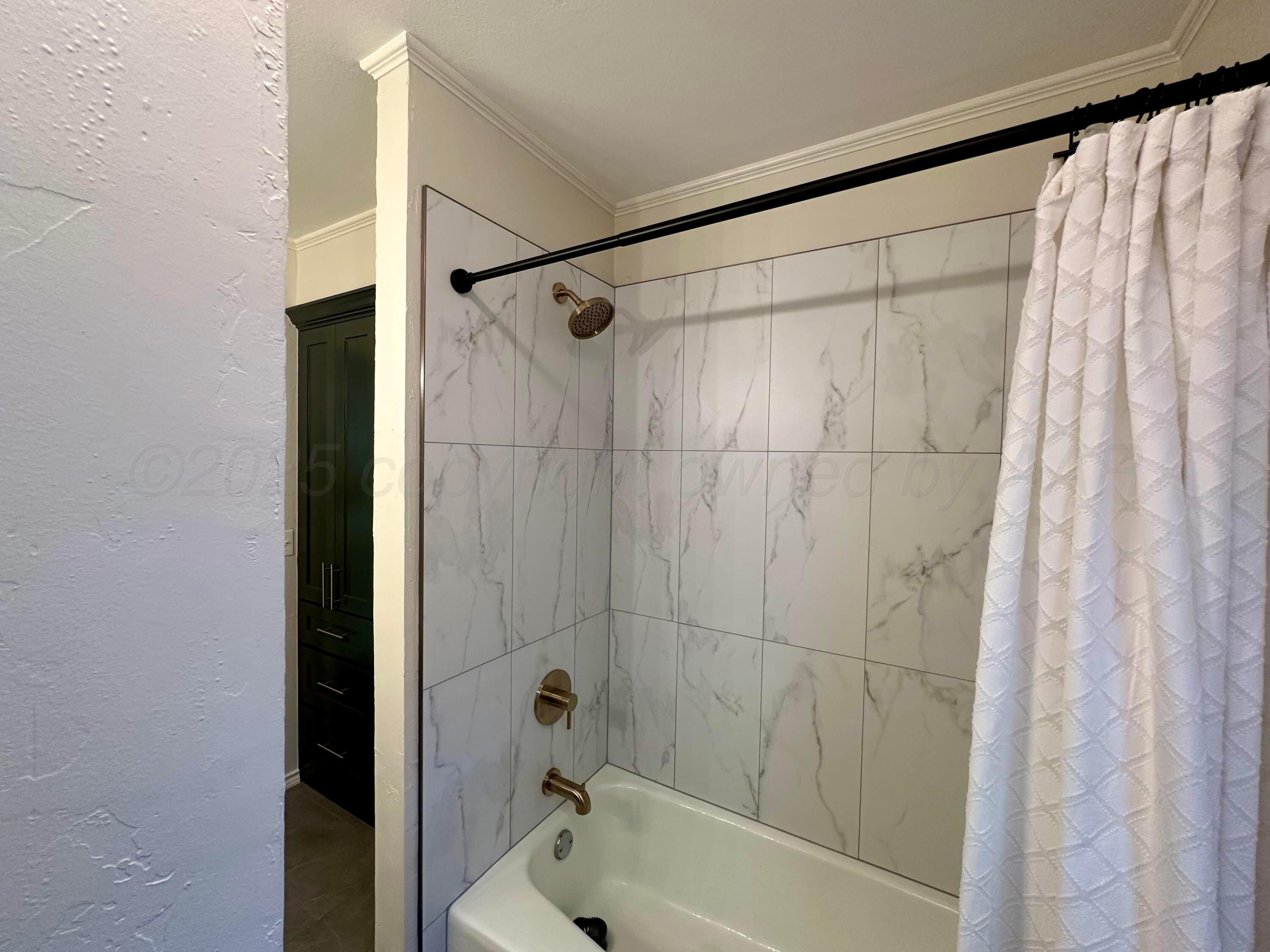 7714 Baughman Drive Amarillo, TX 79121 - Photo 27 of 37 a bathroom with a shower and a tub