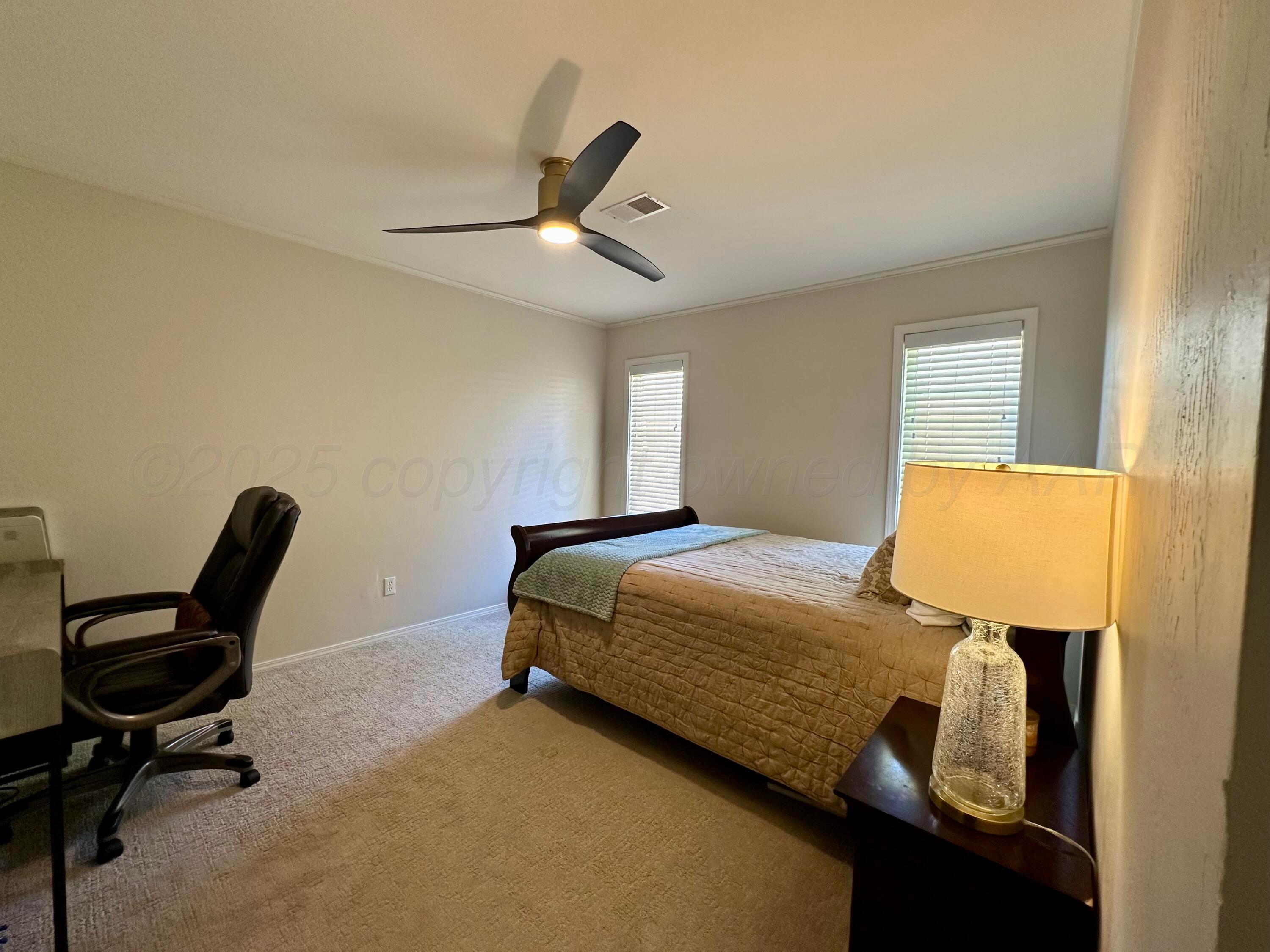 7714 Baughman Drive Amarillo, TX 79121 - Photo 28 of 37 a bedroom with a bed and a desk