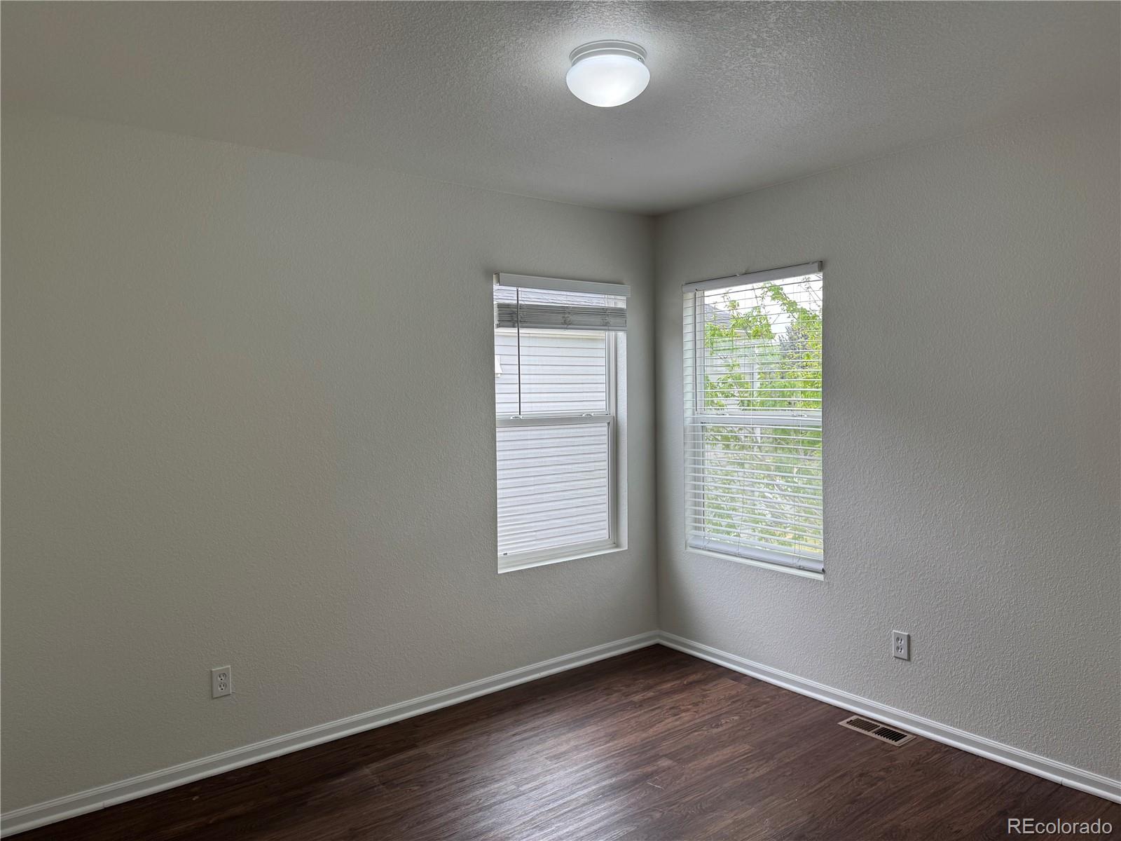 4726 Andes Street Denver, CO 80249 - Photo 11 of 17 an empty room with wooden floor and windows